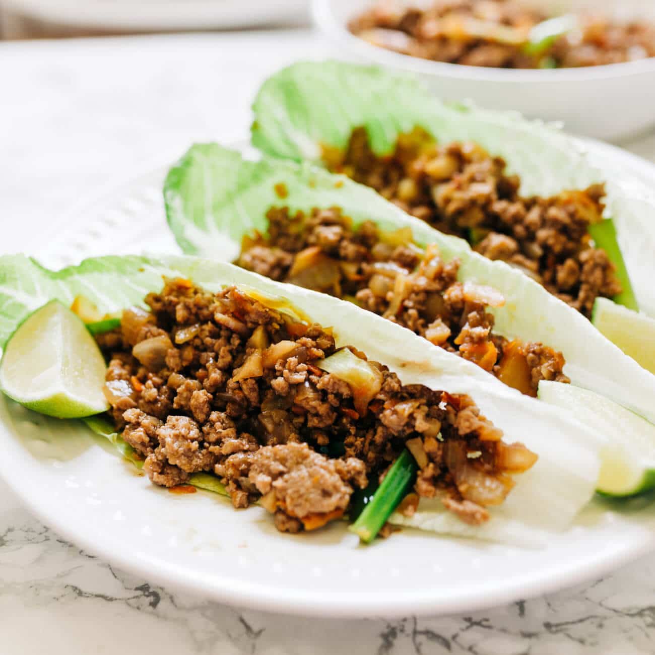 Ground,Beef,Lettuce,Wraps,On,A,Plate,With,Lime,Edges.